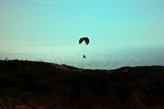 Parachute flying above the sea . Israel .
