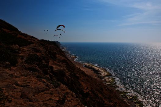 Parachute flying above the sea . Israel .