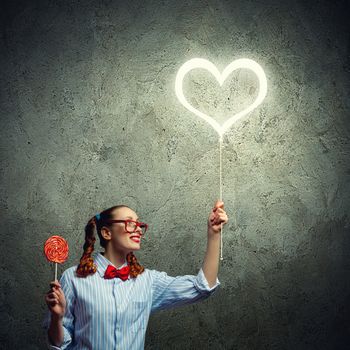 Teenager girl in red glasses with candy. Love concept