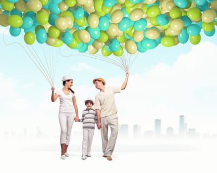 Happy young family walking holding bunch of colorful balloons