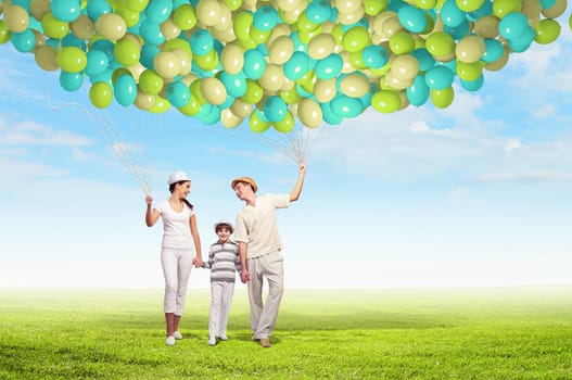 Happy young family walking holding bunch of colorful balloons