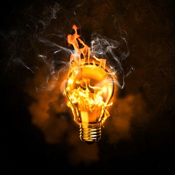 Image of electric bulb in fire flames against black background