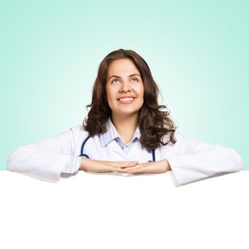 Young attractive female doctor put her hands on the blank banner, place for text