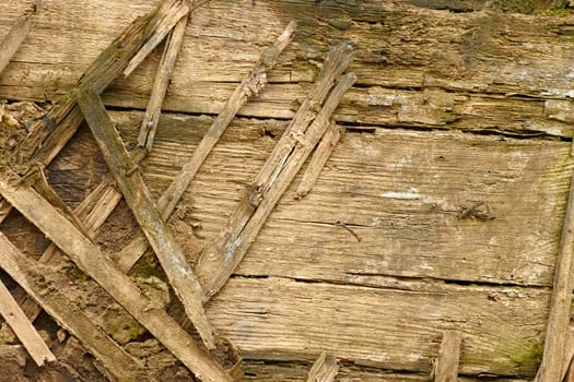 Detail of an old dilapidated wooden walls. Wooden slats are used as fitting with mud