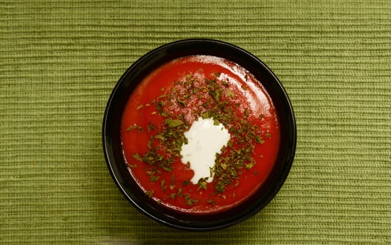 bowl of tomato soup with cream and parsley