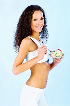 Portrait of a pretty fitness girl holding fresh salad on plate