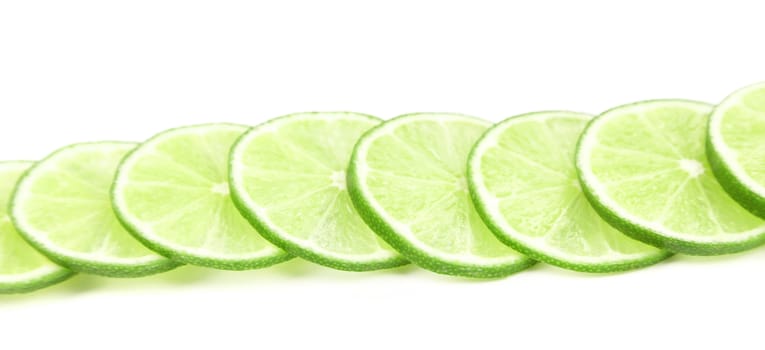 Row lime slices. Close up. White background.