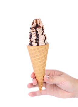 Hand holds ice cream with chocolate topping. White background.