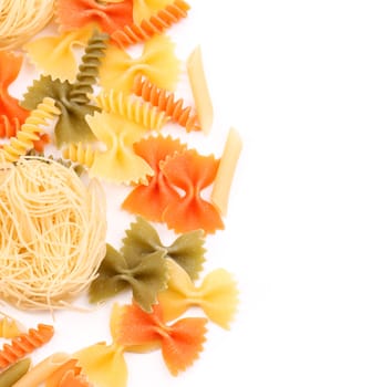 Different pasta in three colors close-up on the white background.