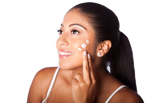 Beautiful happy smiling woman applying facial moisturizing exfoliating lotion cream in face, isolated.