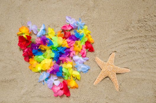 Heart shape of the Hawaiian flowers and starfish on the beach