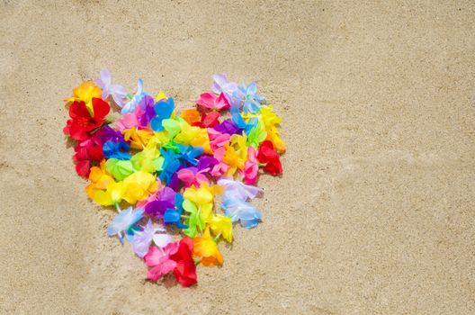 Heart shape of the Hawaiian flowers on sandy beach
