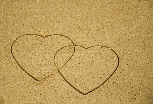 Two hearts drawn on the sandy beach