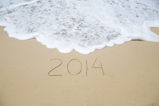Number 2014 on the sandy beach - concept holiday
