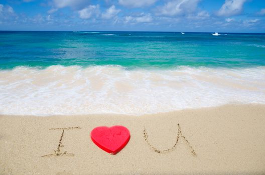 Sign "I Love U" with red heart shape on the beach 