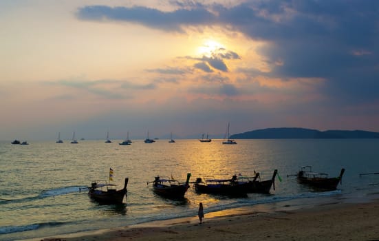 Longtail boats against a sunset. Ao-Nang, Thailand.