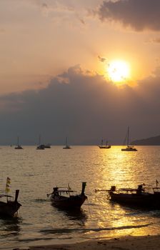 Longtail boats against a sunset. Ao-Nang, Thailand.