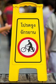 Warning sign Please be guided bike In thai languages.