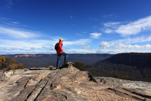 A bushwalker admires the views from Flat Rock Wentworth Falls, Blue Mountains Australia