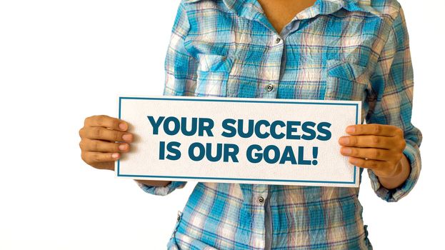 A woman holding a Your Success is our Goal sign.