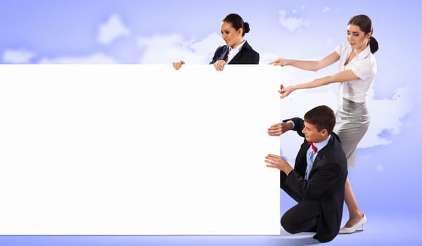 Image of three young people holding blank banner against purple background. Place for text