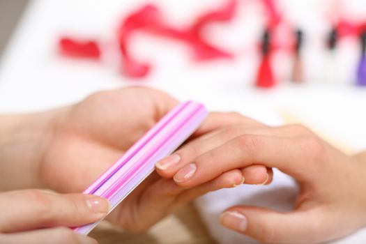 Young woman is getting manicure in a beauty salon