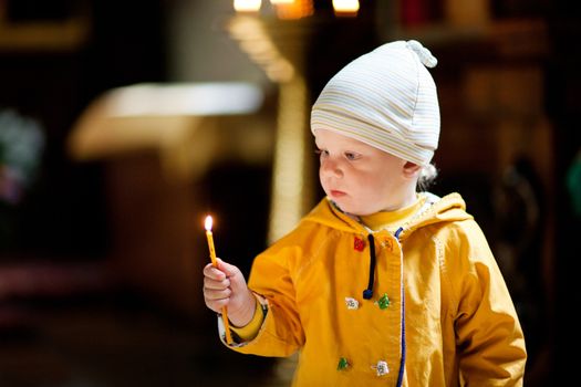 child with candle in the church