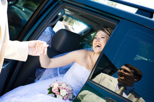 groom helps to bride to leave a car