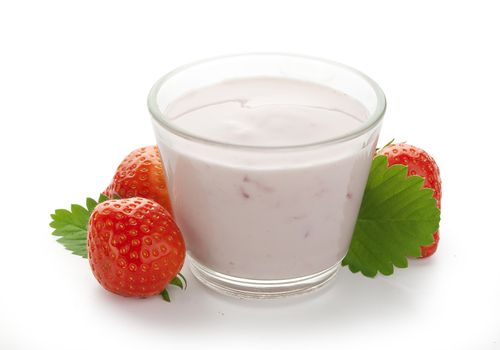 Yoghurt in the glass with strawberry and leaves