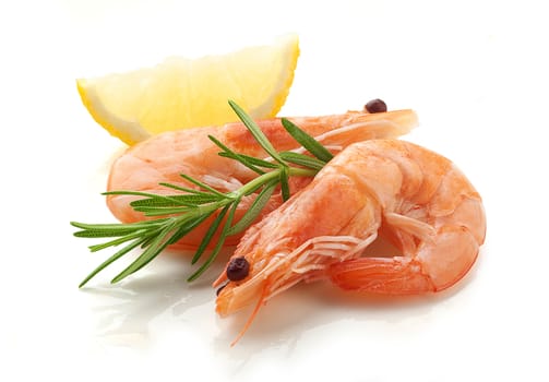 Two raw shrimps with fresh rosemary and lemon on the white