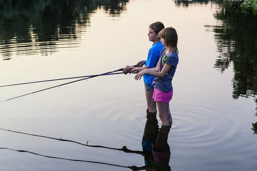 Boy and girl fishing on a lake