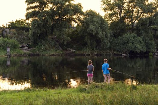 Boy and girl fishing on a lake