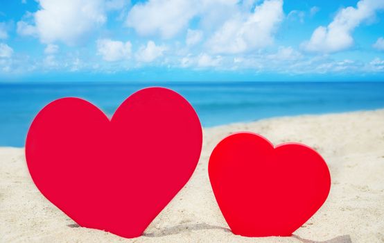 Two red Heart shape on sandy beach