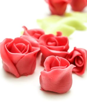Pink marzipan roses towards white with green petals in the background