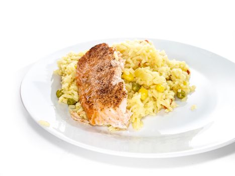 Fried salmon on white plate with risotto towards white