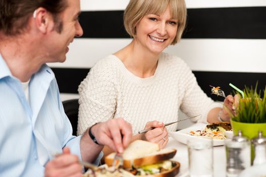 Couple recalling old memories while dining in a food court.