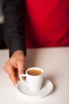 Barista prepares cappuccino in his coffee shop.