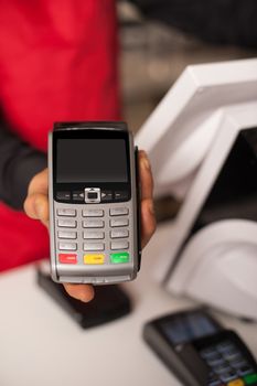 Barista staff offering card swipe service to accept payment.