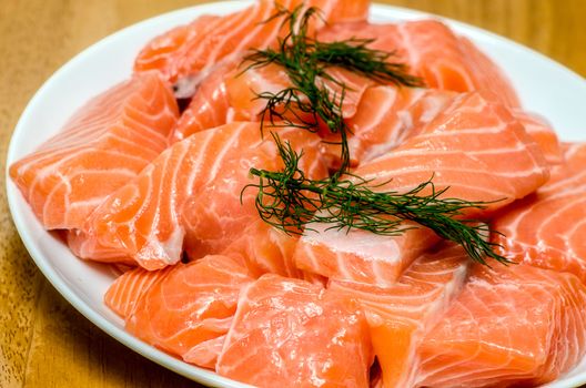 fresh salmon with dill on white plate