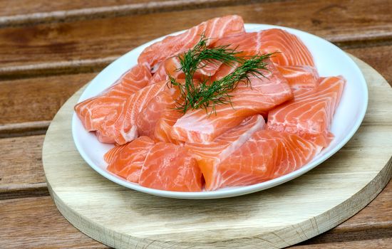 fresh salmon with dill on white plate