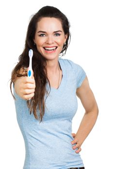 A happy beautiful woman with perfect teeth holding out a toothbrush. Isolated on white.