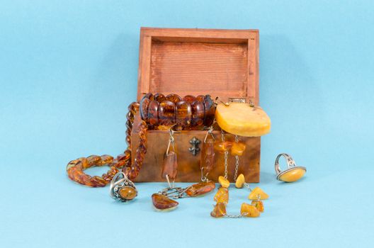 amber stone apparel jewelry ring bracelet in retro wooden box on blue background.