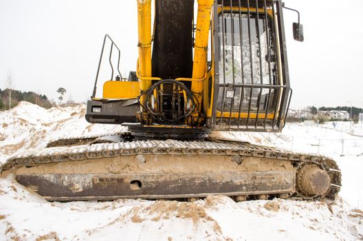 closeup of caterpillar excavator tractor driver cabin covered with snow in winter. heavy machinery industry.