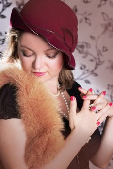 Retro woman in hat and boa with eyes closed over vintage back