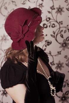 Elegant retro woman in vintage hat half face over glamorous back
