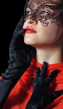 Girl in a Venetian masquerade mask isolated on a black background