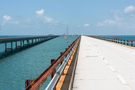 The Seven Mile bridge was built by Henry Flagler as part of the Overseas Railroad to Key West. After a hurricane shut down the railroad, Florida purchased this bridge and used it as part of the overseas highway to Key West. Today this 2.2 mile section is used for pedestrians, fishermen, and bicyclists and connects to Pigeon Key. The new seven mile bridge can be seen running alongside the old bridge.