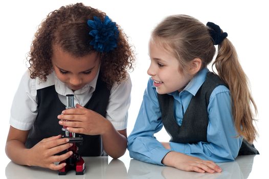 School girls using a microscope in lab