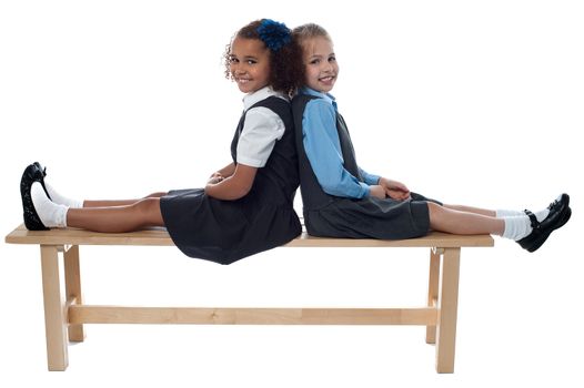 Cheerful kids relaxing on school bench