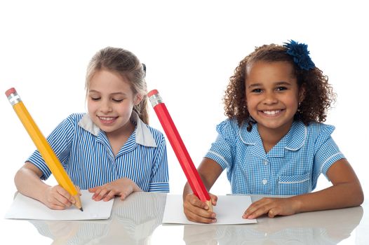 Smiling kids writing their annual exam
